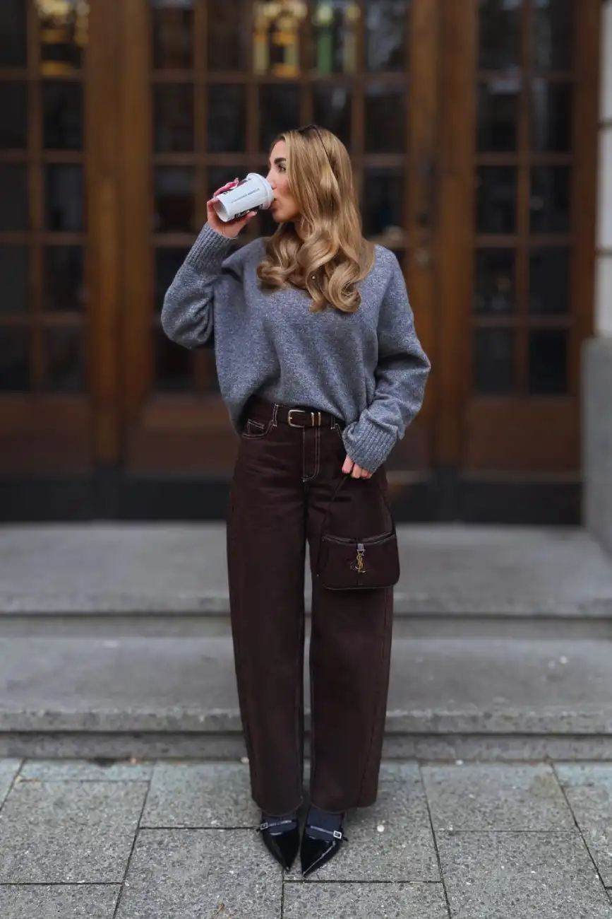 Woman wearing a cozy gray sweater with wide-leg chocolate brown pants and black pointed-toe shoes