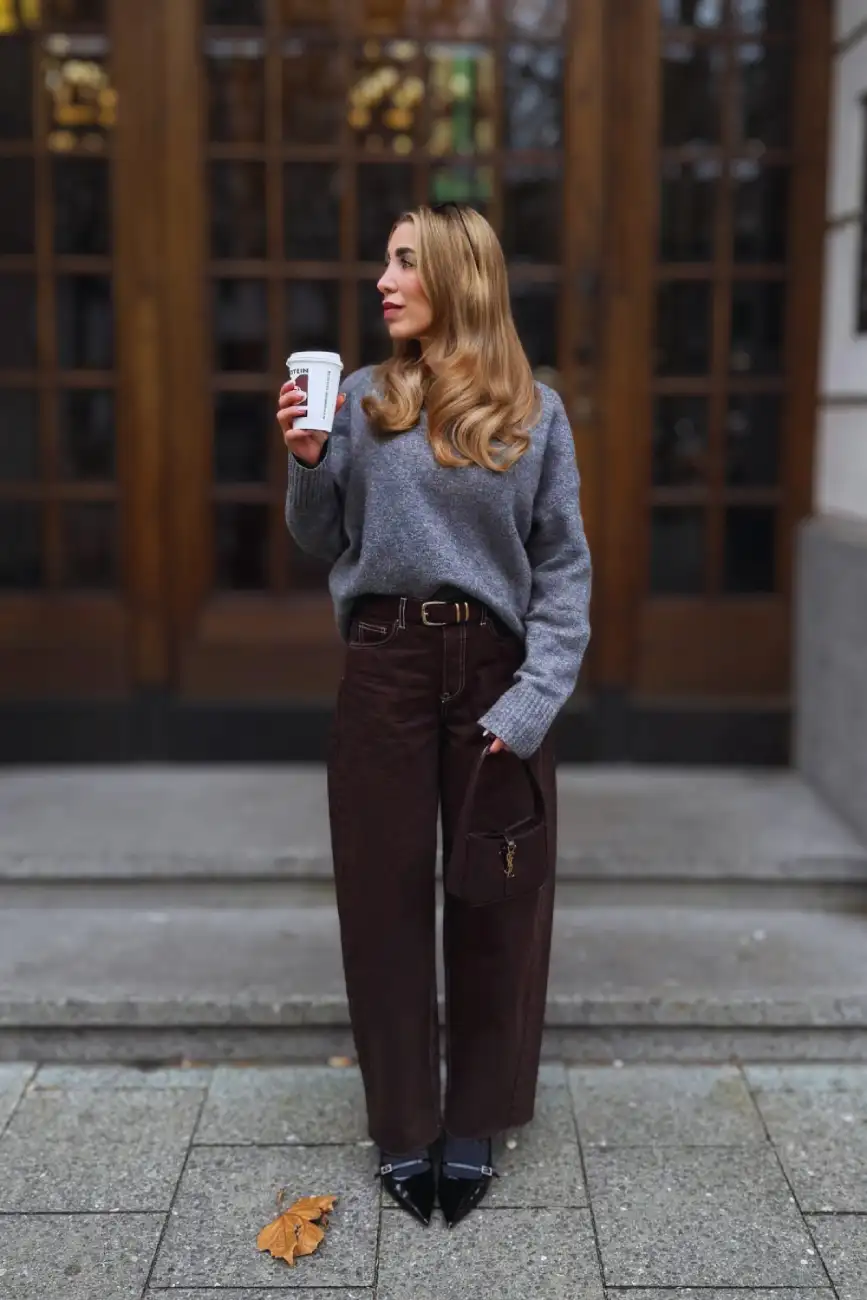Side profile of a cozy gray sweater tucked into chocolate brown wide-leg pants while holding a coffee - Inspiration 3